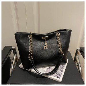 Nahaufnahme der schwarzen Tote-Bag mit goldener Kette und kleinem Hirsch-Anhänger