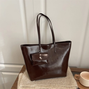 Minimalist chocolate brown patent leather tote bag with small matching purse on scarf