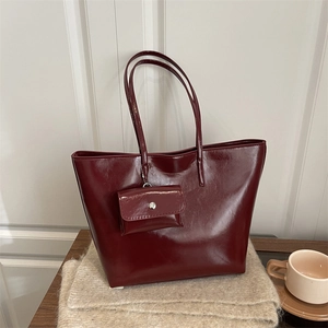 Deep red large capacity tote bag with matching pouch on a soft knit blanket