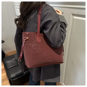 Detailed close-up of burgundy leopard print tote bag with soft matte finish and side straps
