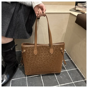 Detail of vintage leopard print tote bag with brown leather straps and gold metal hardware