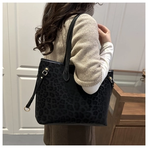 Detailed shot of large leopard print tote bag with gold metal buckles and slim straps