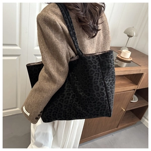 Leopard print tote bag shown from a side view in a cozy lifestyle setting with warm tones