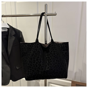 Macro shot of large black leopard print tote bag with soft flocked texture and slim straps