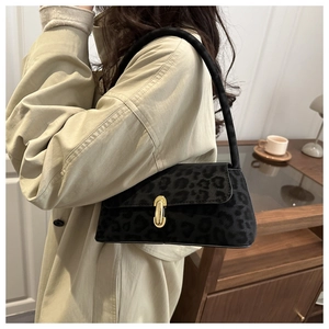 Détail du sac sous le bras en daim léopard avec boucle en métal doré élégante