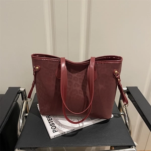 Vintage burgundy leopard print tote bag with gold metal rings and long shoulder straps