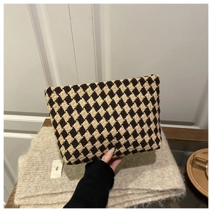Close-up of checkered jacquard weave texture on a brown and beige portable makeup bag