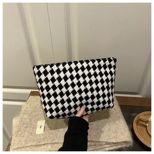 Macro shot of black and white checkered jacquard texture on a luxury storage pouch