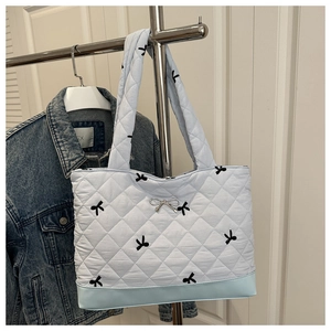 Detail van gewatteerde lichtblauwe shopper met zwarte strikprint en zilveren hanger