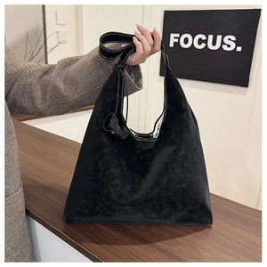 Macro shot of black frosted faux leather tote bag showing white stitching and matte texture
