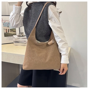 Detail of light brown vintage tote bag with soft leather texture and stylish knot detail