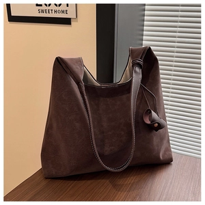 Close-up of retro brown leather tote with white contrast stitching and knotted strap detail