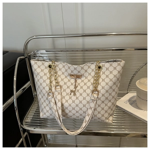 Détail du sac cabas monogramme avec bandoulière chaîne dorée et pendentif cerf