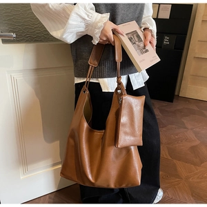 Brown leather tote bag detail with matching side zipper pouch and soft texture finish