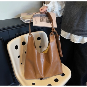 Detailed view of a brown leather Hobo tote bag with a matching mini zipper pouch