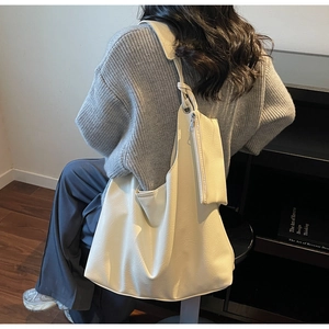Minimalist beige tote bag featuring a moon-shaped hobo design and detachable coin purse