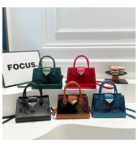 Detailed view of crocodile and snake texture leather handbags with triangular metal locks