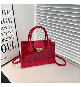 Dettaglio della trama a serpente rossa e della chiusura dorata sulla borsa da donna