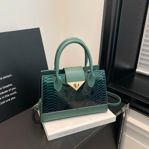 Borsa a mano verde scuro con goffratura serpente e chiusura dorata su libro