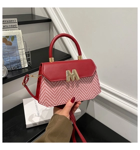 Detail of red stripe fabric mini bag with golden M hardware and adjustable strap
