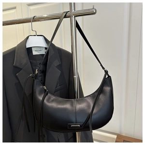 Détail du sac demi-lune noir minimaliste avec finition cuir et fermeture à frange
