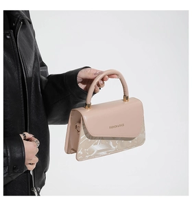 Detalle de bolso cuadrado beige con texto 'FASHION & BAGS' y diseño geométrico chic