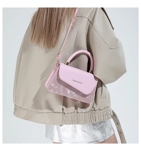 Vista lateral del bolso rosa con empalme de PVC llevado por modelo en chaqueta beige