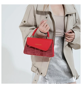 Detalle de bolso rojo de moda con asa dorada y textura de malla con diseño de letras LOVE
