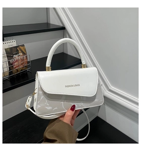 Detalle de bolso blanco de cuero con herrajes dorados y logotipo Fashion & Bags