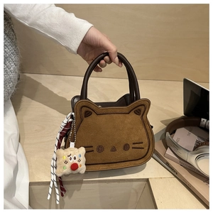 Detail van schattige bruine kat-handtas met borduursel en geweven riemaccessoire