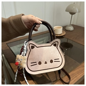Detail van kattenborduurwerk en pluche hanger op de roze suède handtas van hoge kwaliteit