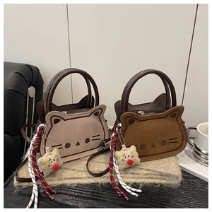 Detail of cute cat embroidery on matte suede handbags with fuzzy biscuit charms