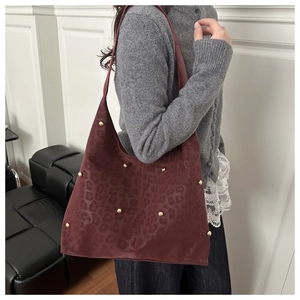 Detail of burgundy leopard print hobo bag with gold rivet studs and suede texture