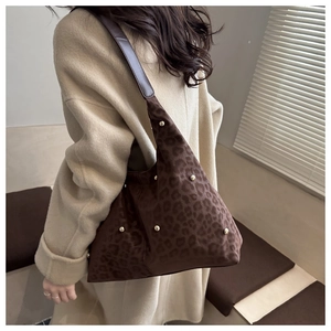 Detail of leopard print hobo bag featuring gold studs and dark brown leather strap