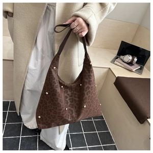 Detail of leopard print hobo bag with gold studs and brown leather shoulder strap