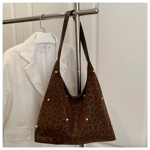 Dettaglio della borsa tote scamosciata leopardata con borchie dorate e tracolla