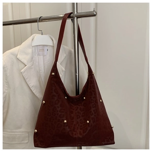 Dettaglio borsa hobo bordeaux goffrata leopardo con borchie dorate su rack