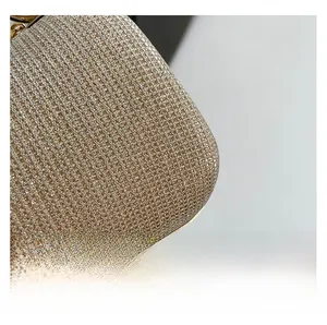 Detailed close-up of glittering metallic woven fabric and gold-tone metal edge on party bag