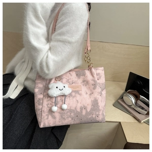 Detail of pink star moon tote with golden chain strap and white cloud plush charm
