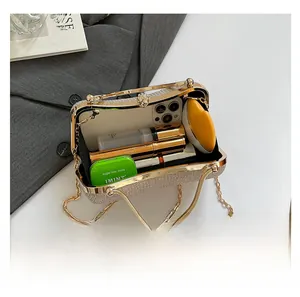 Interior capacity of woven beige evening clutch showing phone, lipstick and essentials