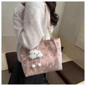 Close-up of pink tote bag with silver star moon print and a plush cloud charm