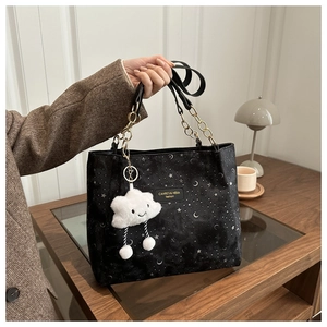 Detail of starry night tote bag with gold chain handles and cloud plush charm