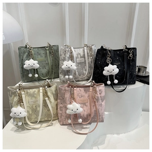 Detail view of colorful star and moon print tote bags with plush cloud charms and chain handles