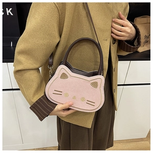 Detailansicht der rosa Katzen-Handtasche mit Goldstickerei und Wildleder-Textur