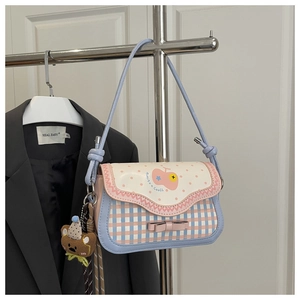 Detail of pink apple-shaped handbag with polka dots, bow detail and cute bear charm