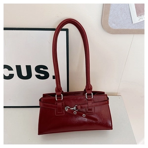 Detailopname van bordeauxrode lederen tas met vintage gespen en dubbele schouderbanden