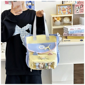 Detail der Canvas-Schultertasche mit klarem PVC-Fensterfach und süßem Plüsch-Anhänger