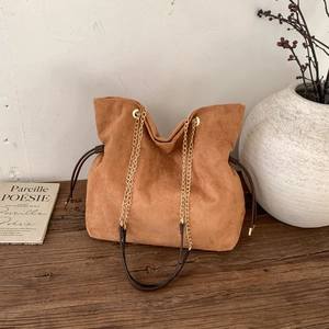 Borsa tote vintage marrone opaca con tracolla a catena e coulisse su legno