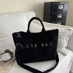 Large black corduroy tote bag with white embroidery and adjustable shoulder strap