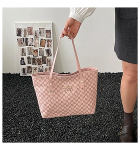 Vue détaillée du sac cabas rose avec imprimé monogramme et nœud métallique doré